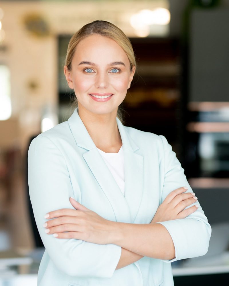 Young female business leader with her arms crossed on chest Young female business leader with her arms crossed on chest standing in front of camera in office