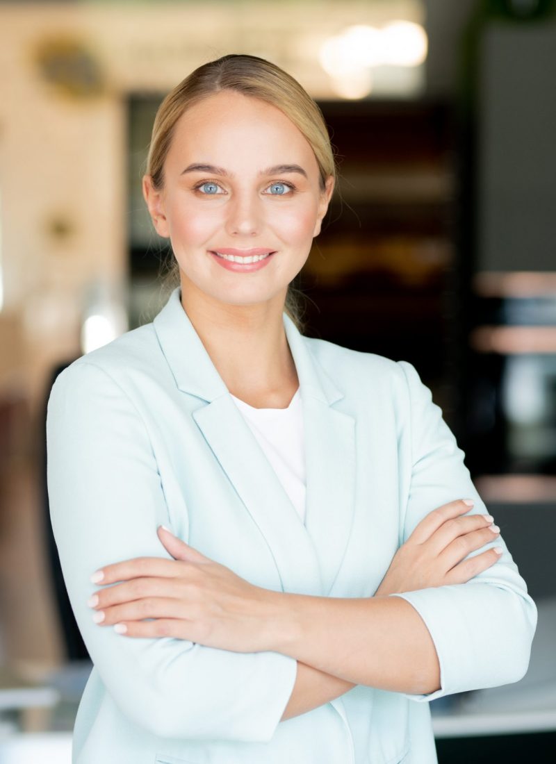 Young female business leader with her arms crossed on chest Young female business leader with her arms crossed on chest standing in front of camera in office